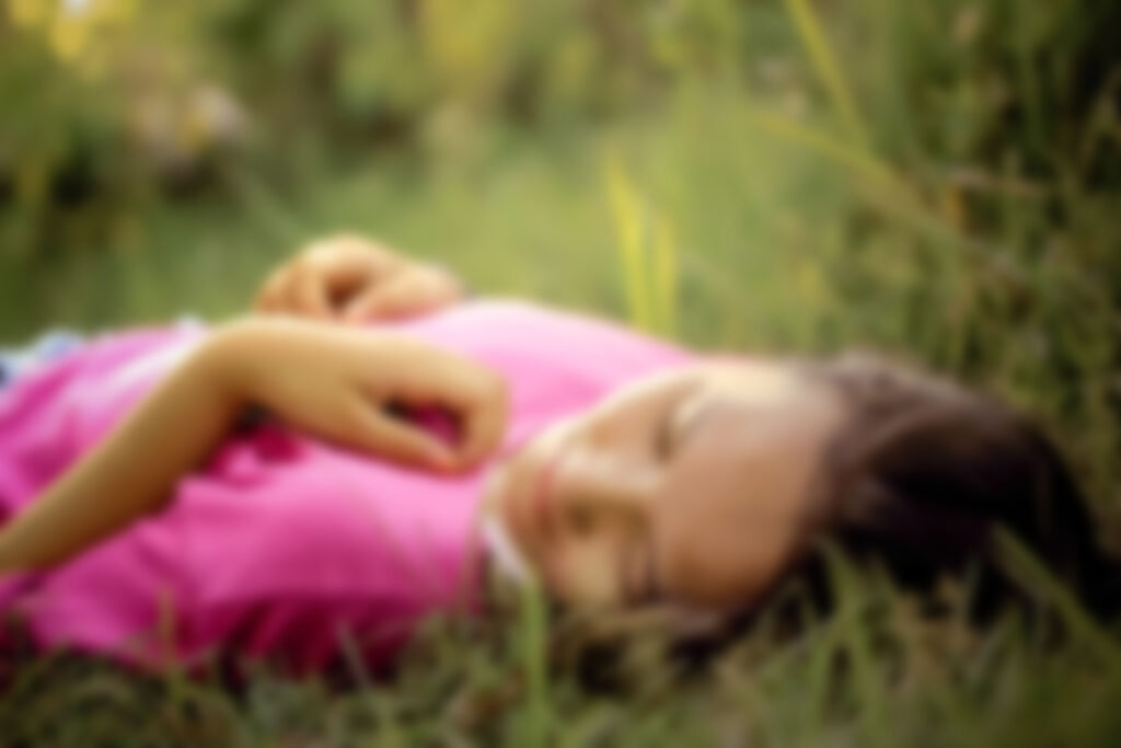 woman laying in the grass.  Image by Heri Santoso